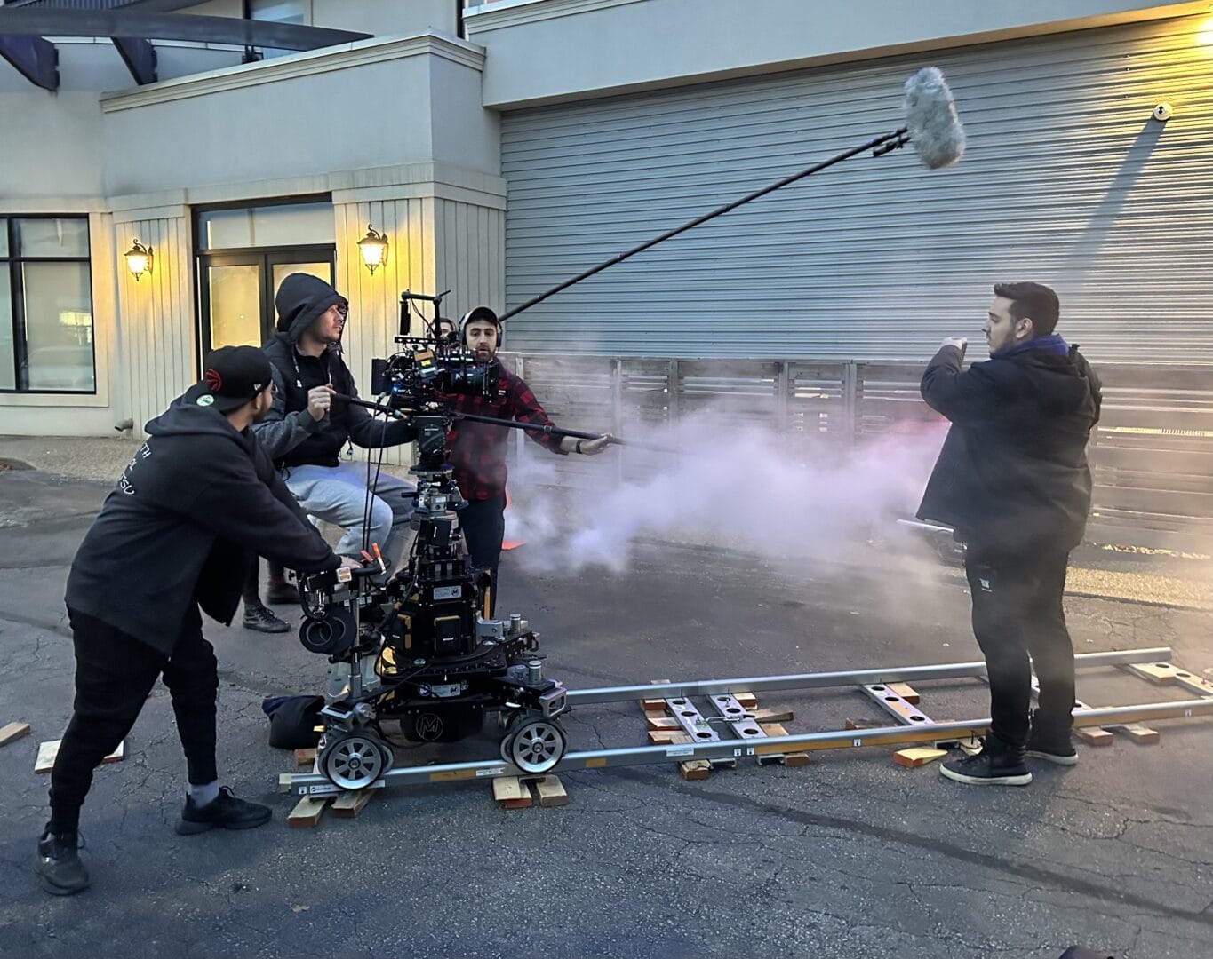 Image showing a foggy filmmaking set with filmmakers using a camera on a dolly.  