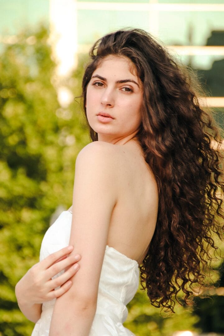 A woman with long curly hair posing for a picture.
